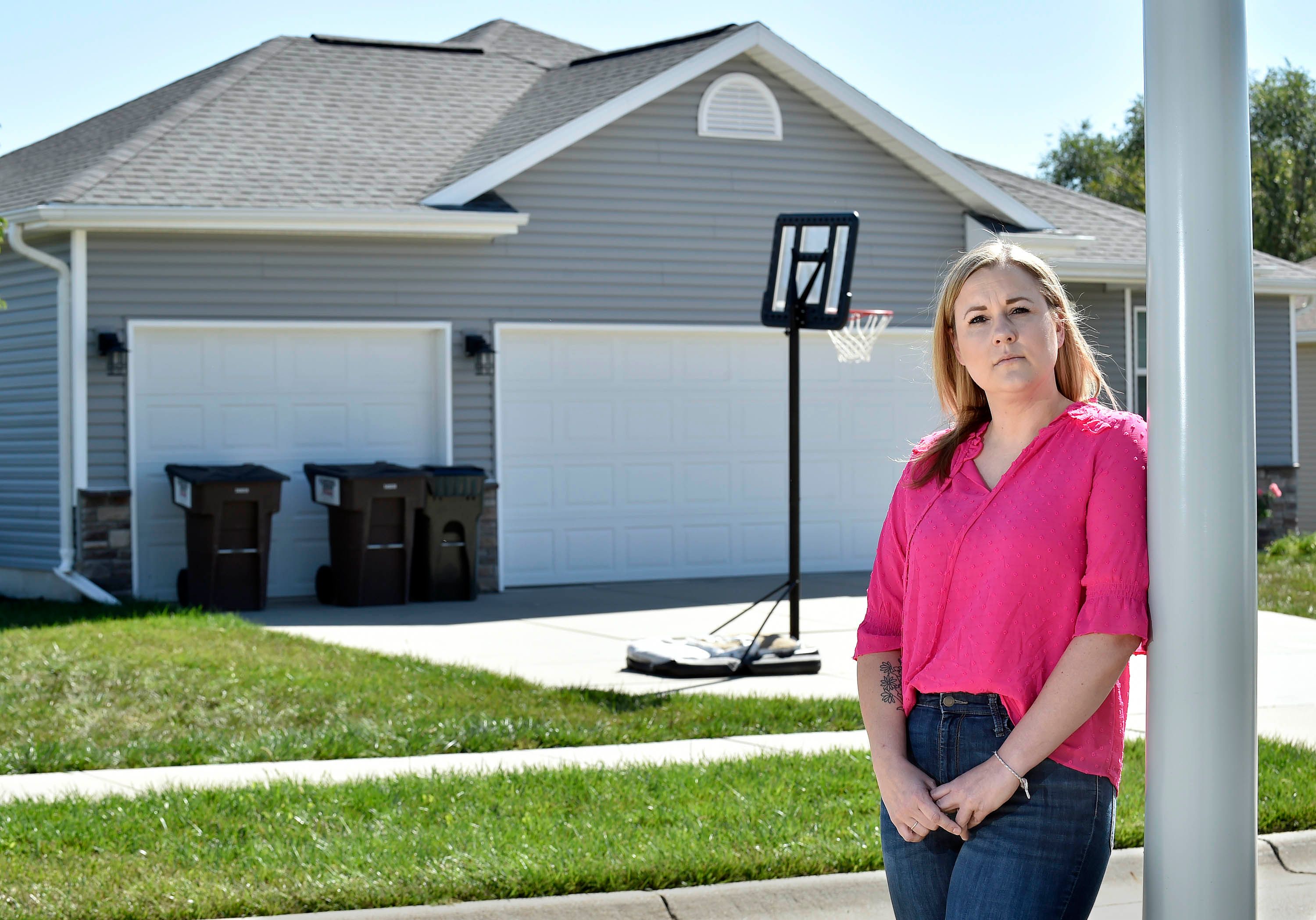Jenn Burruss stands outside her home in Hickman, Nebraska, Sunday, Sept. 24. Burruss was shocked recently when she learned that her homeowner's insurance premium had doubled in one year.