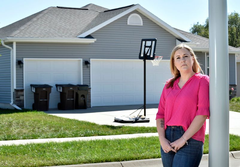 Jenn Burruss stands outside her home in Hickman, Nebraska, Sunday, Sept. 24. Burruss was shocked recently when she learned that her homeowner's insurance premium had doubled in one year.